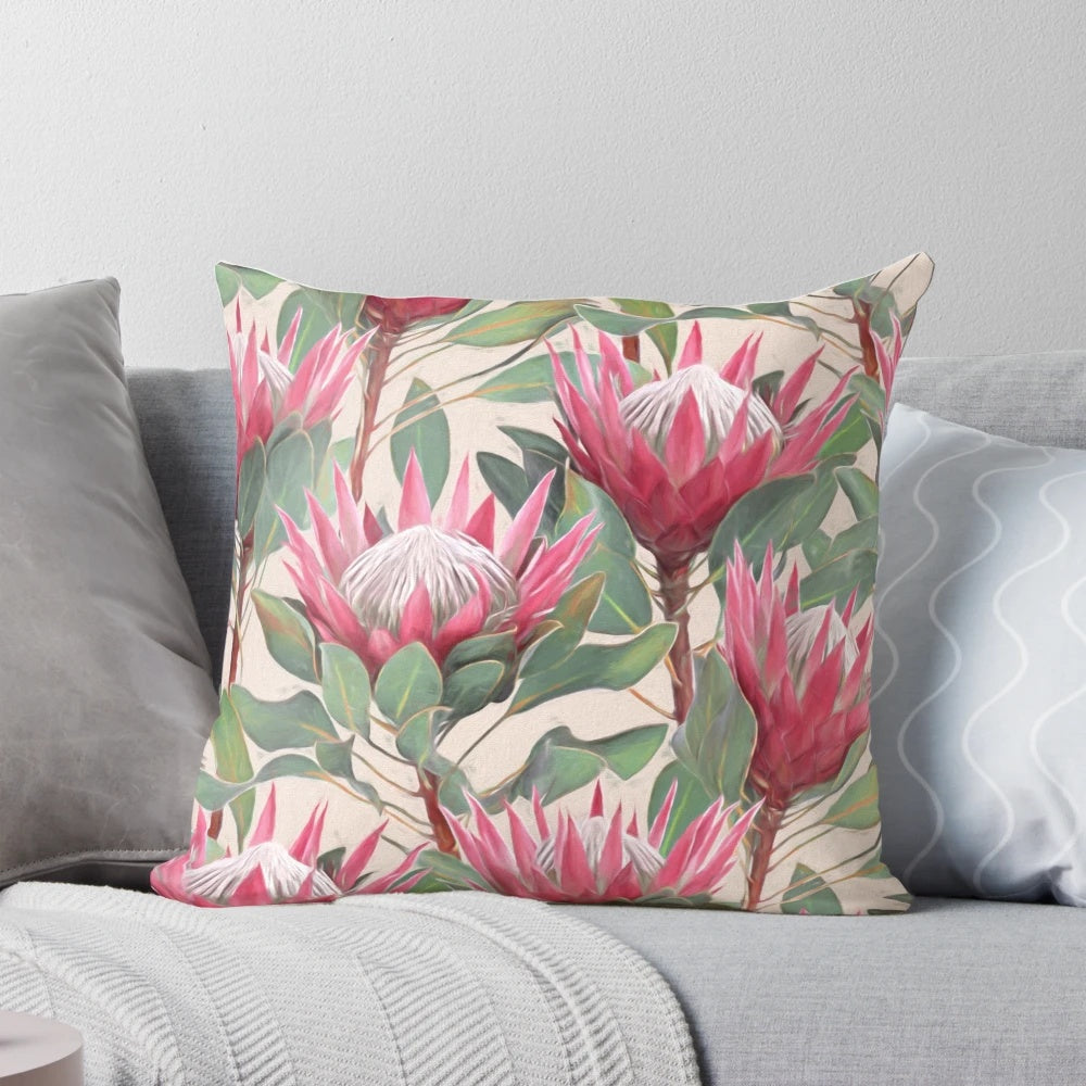 Cream-colored pillow with a painted design of vibrant king proteas and other botanical elements.