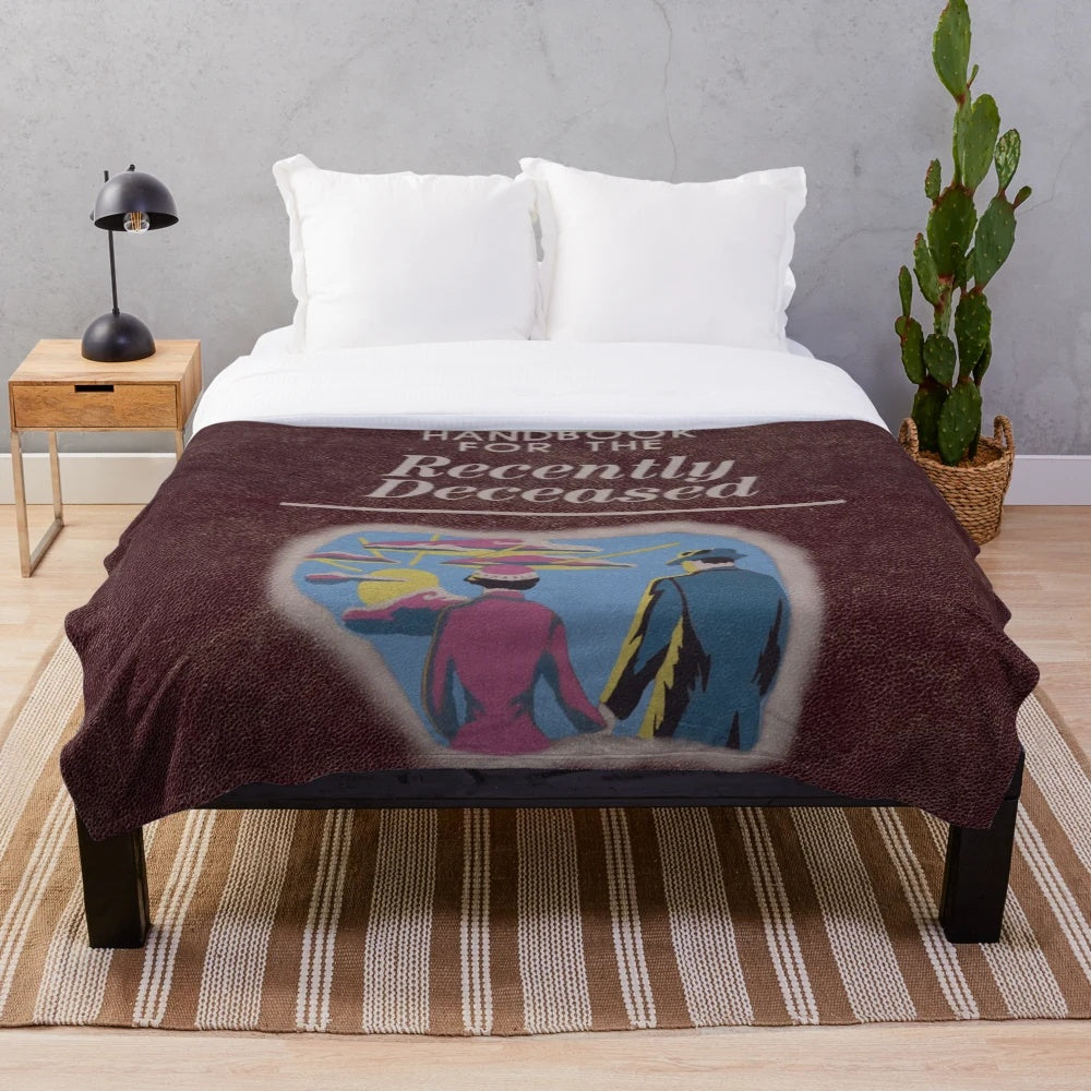 Beetlejuice-inspired plush blanket with "Handbook for the Recently Deceased" design