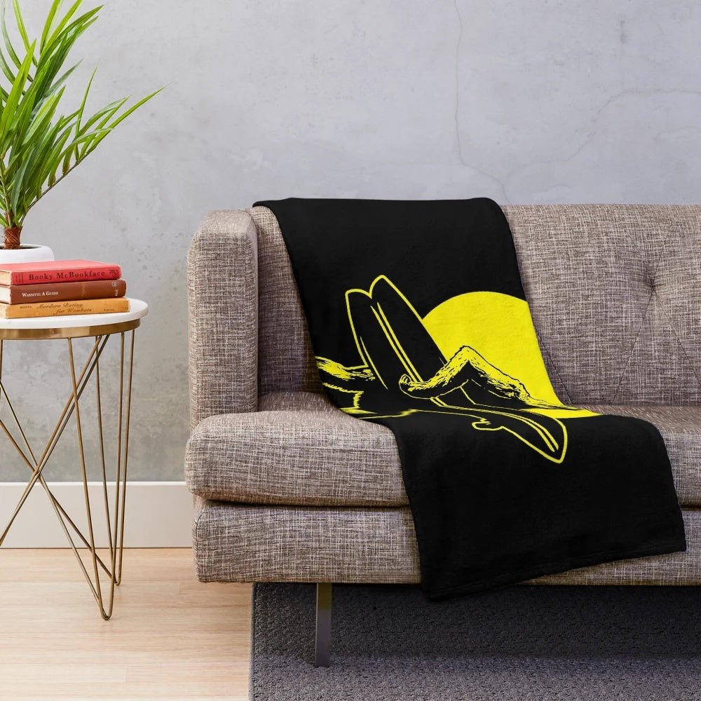 A plush blanket featuring a Bigfoot surfer design, inspired by cryptozoology and alternative culture