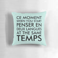 A black pillow with the text "Thinking in French and English" printed on it.
