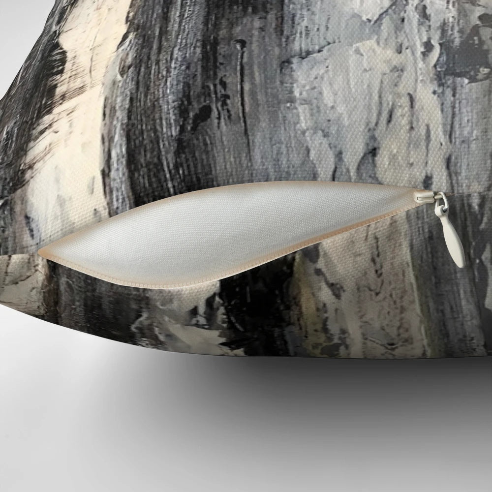 A modern, minimalist black and white pillow featuring an abstract design of birch trees.