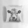 A black and white decorative cow throw pillow