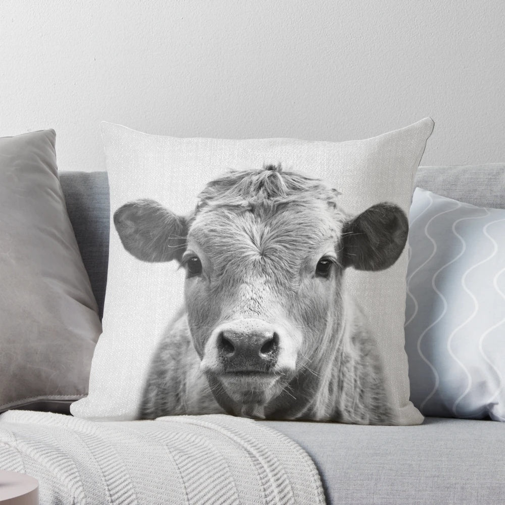 A black and white decorative cow throw pillow
