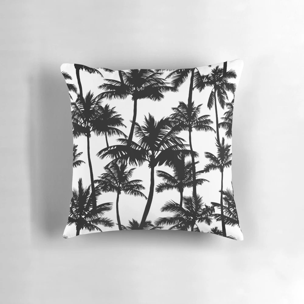 A black and white pillow cover featuring a pattern of detailed palm tree silhouettes against a plain white background.
