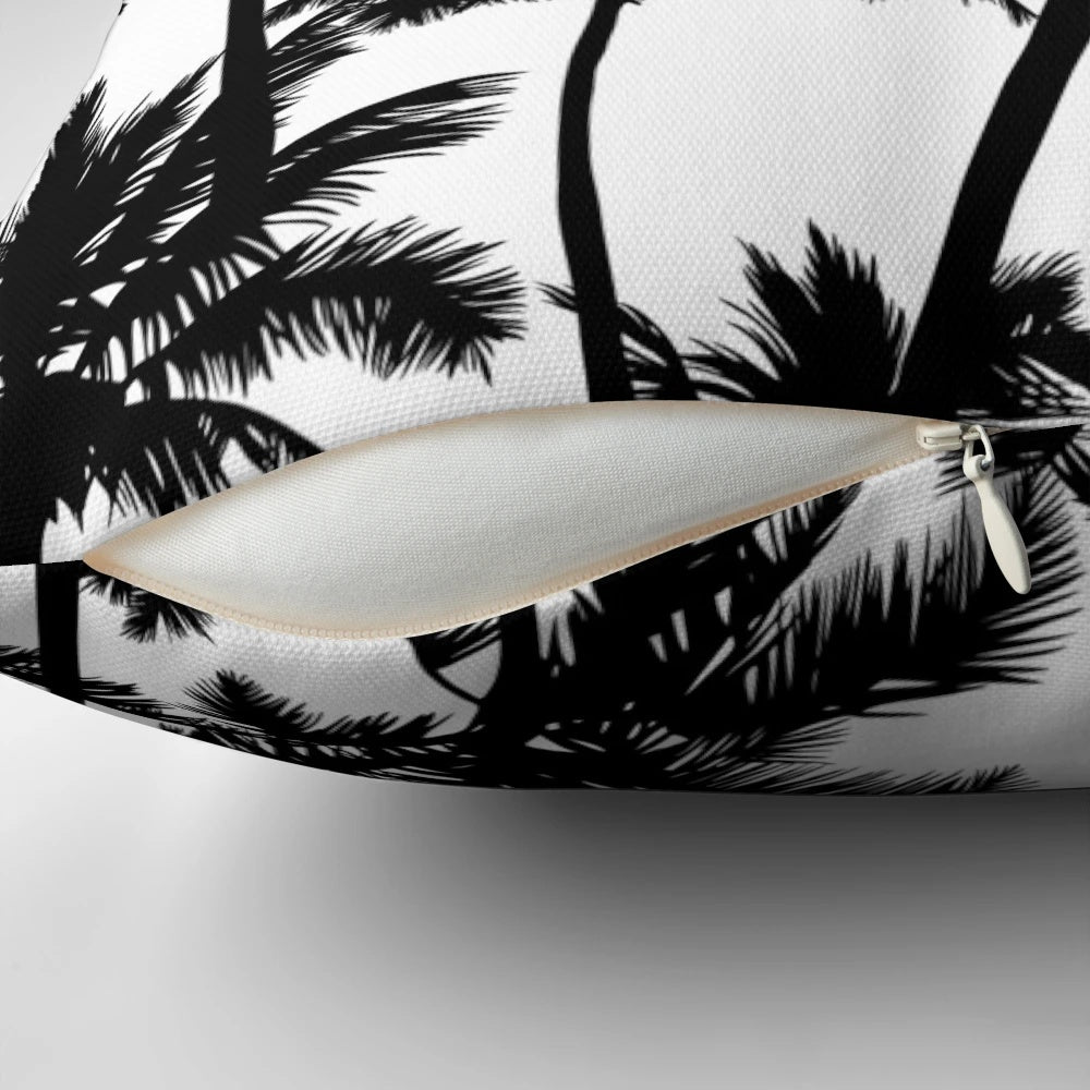 A black and white pillow cover featuring a pattern of detailed palm tree silhouettes against a plain white background.