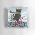 Black cat riding a bicycle with Christmas decorations on a pillow
