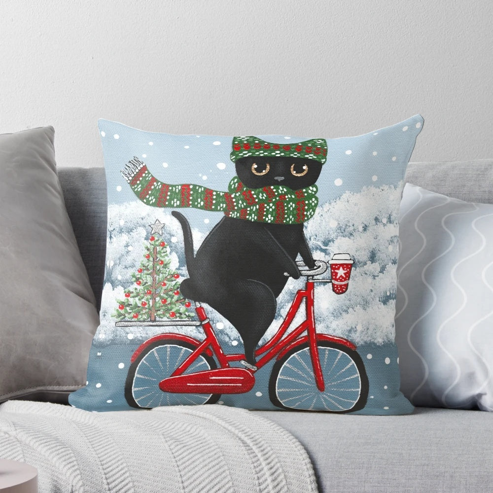 Black cat riding a bicycle with Christmas decorations on a pillow