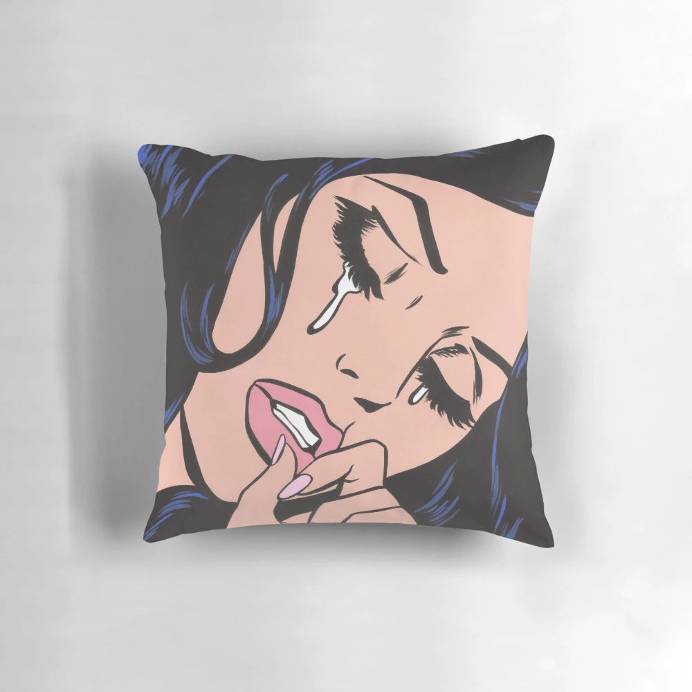 Black and white comic-style illustration of a crying woman with black hair on a decorative throw pillow.