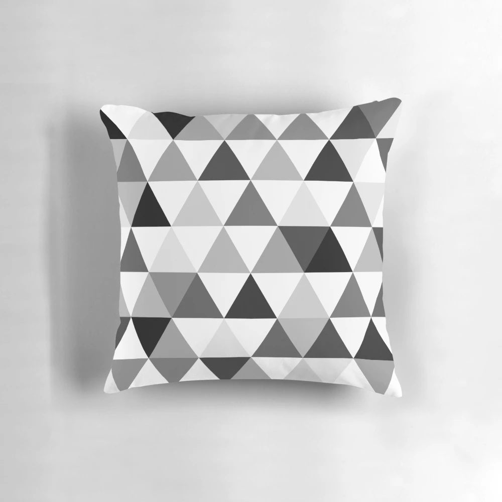 A decorative throw pillow featuring a modern, abstract design of triangles in black, grey, and white with a 3D, optical illusion effect.