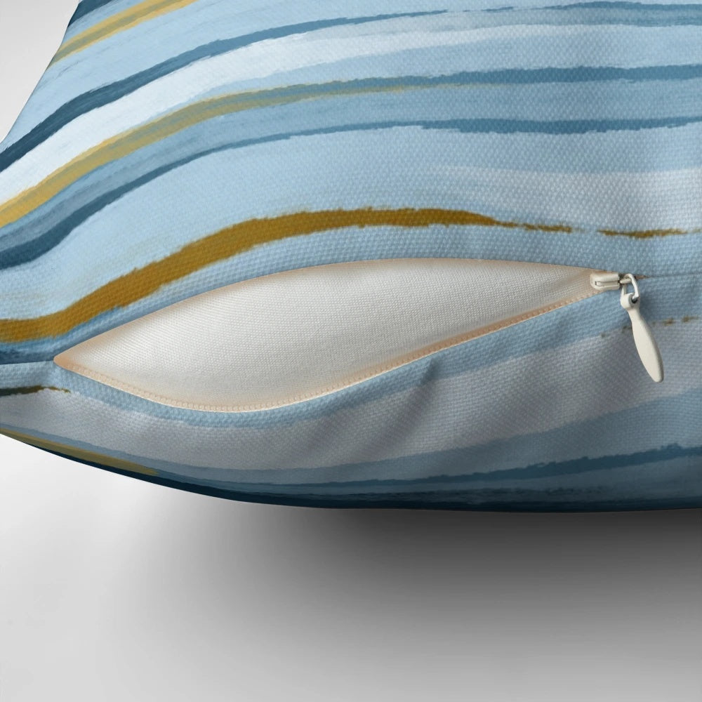 A blue and yellow minimalist throw pillow with abstract lines and geometric patterns