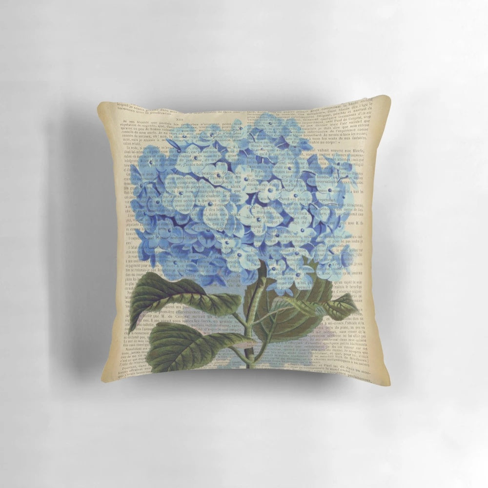 Blue hydrangea flowers printed on an aged, vintage book page, decorative pillow.