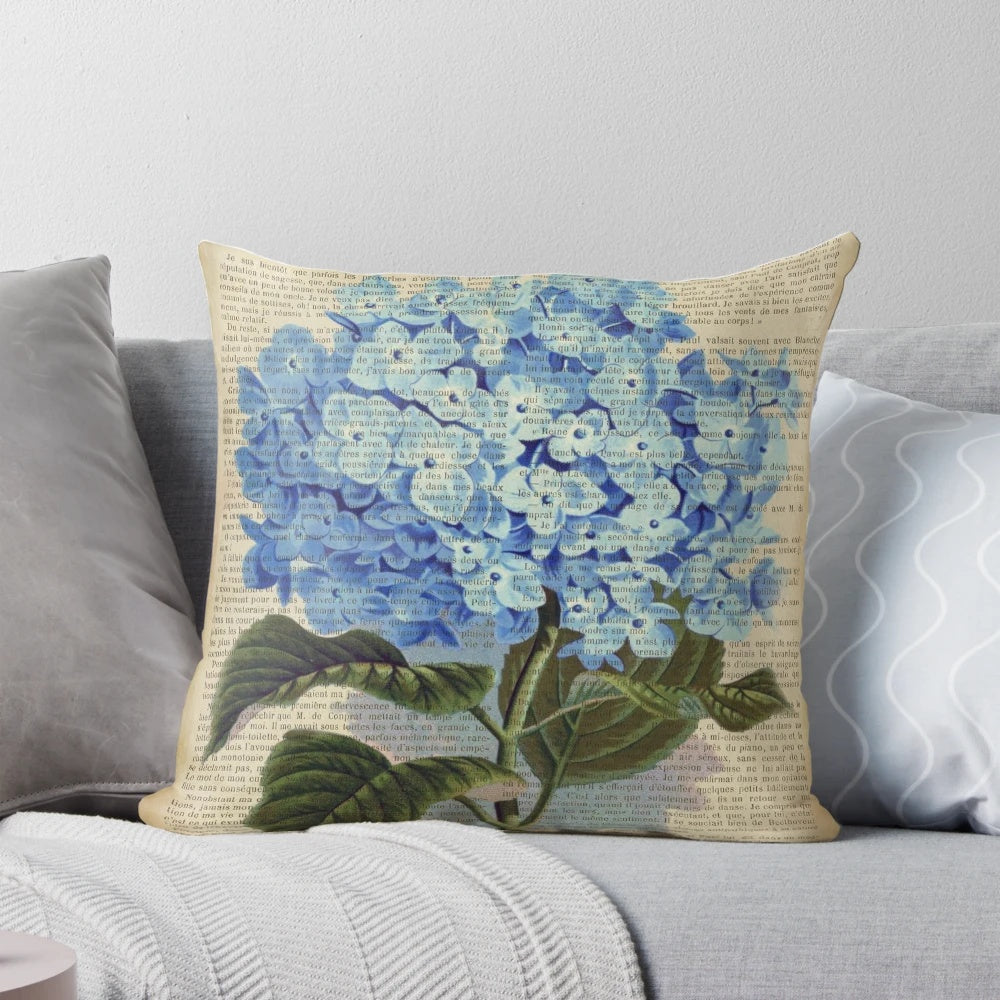 Blue hydrangea flowers printed on an aged, vintage book page, decorative pillow.