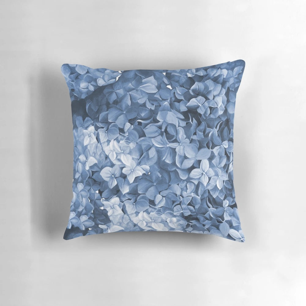 Vibrant blue hydrangea flowers in an oil painting-inspired design on a decorative pillow.