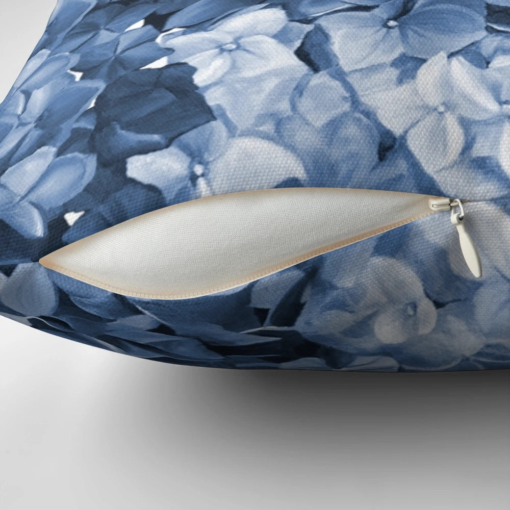 Vibrant blue hydrangea flowers in an oil painting-inspired design on a decorative pillow.