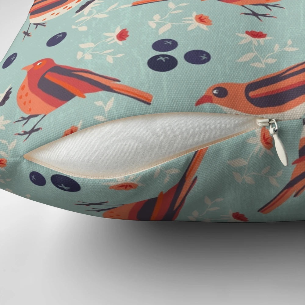 A colorful vintage-style pillow featuring a bluebird and floral pattern in shades of blue, orange, red, beige, and green.
