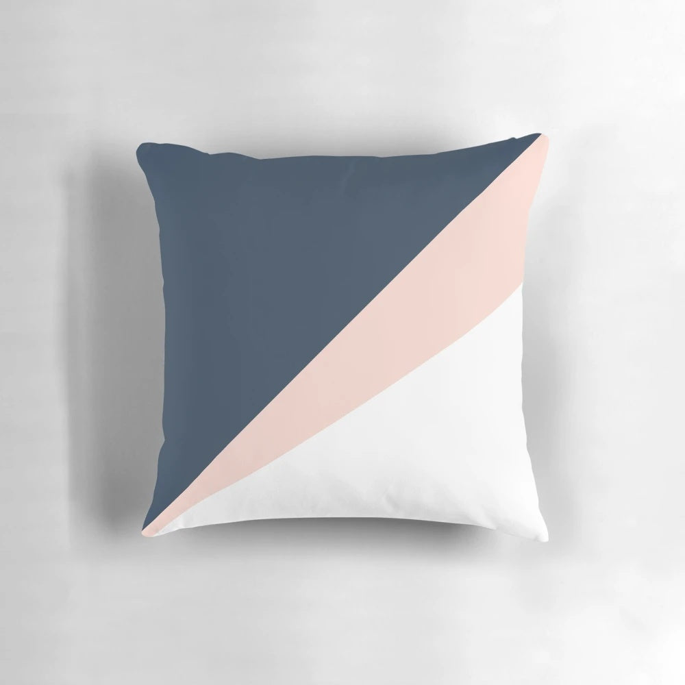Blush pink and navy blue geometric triangle pillow with a minimalist, modern design
