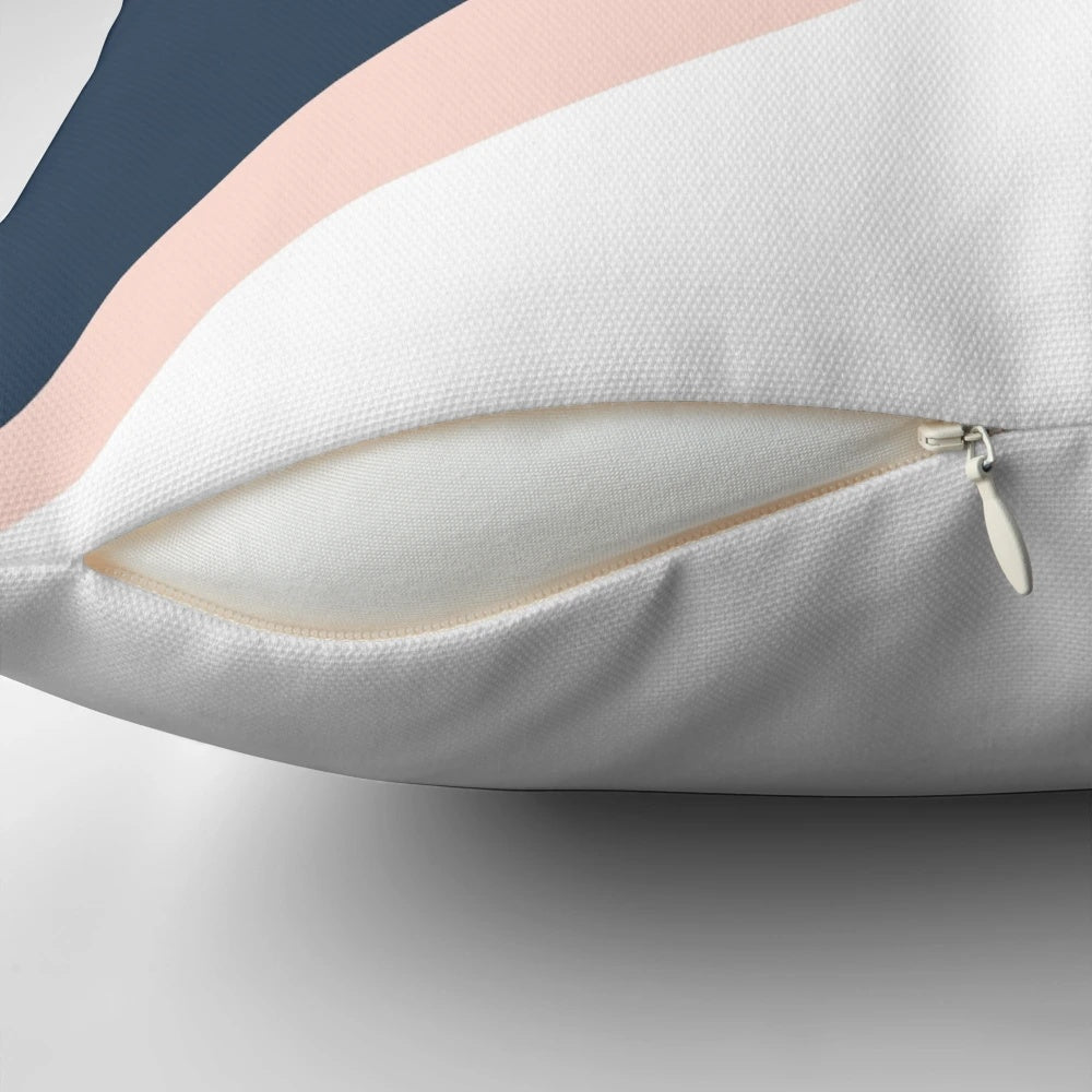 Blush pink and navy blue geometric triangle pillow with a minimalist, modern design