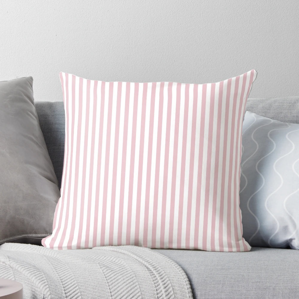 A decorative pillow with blush pink and white vertical stripes.