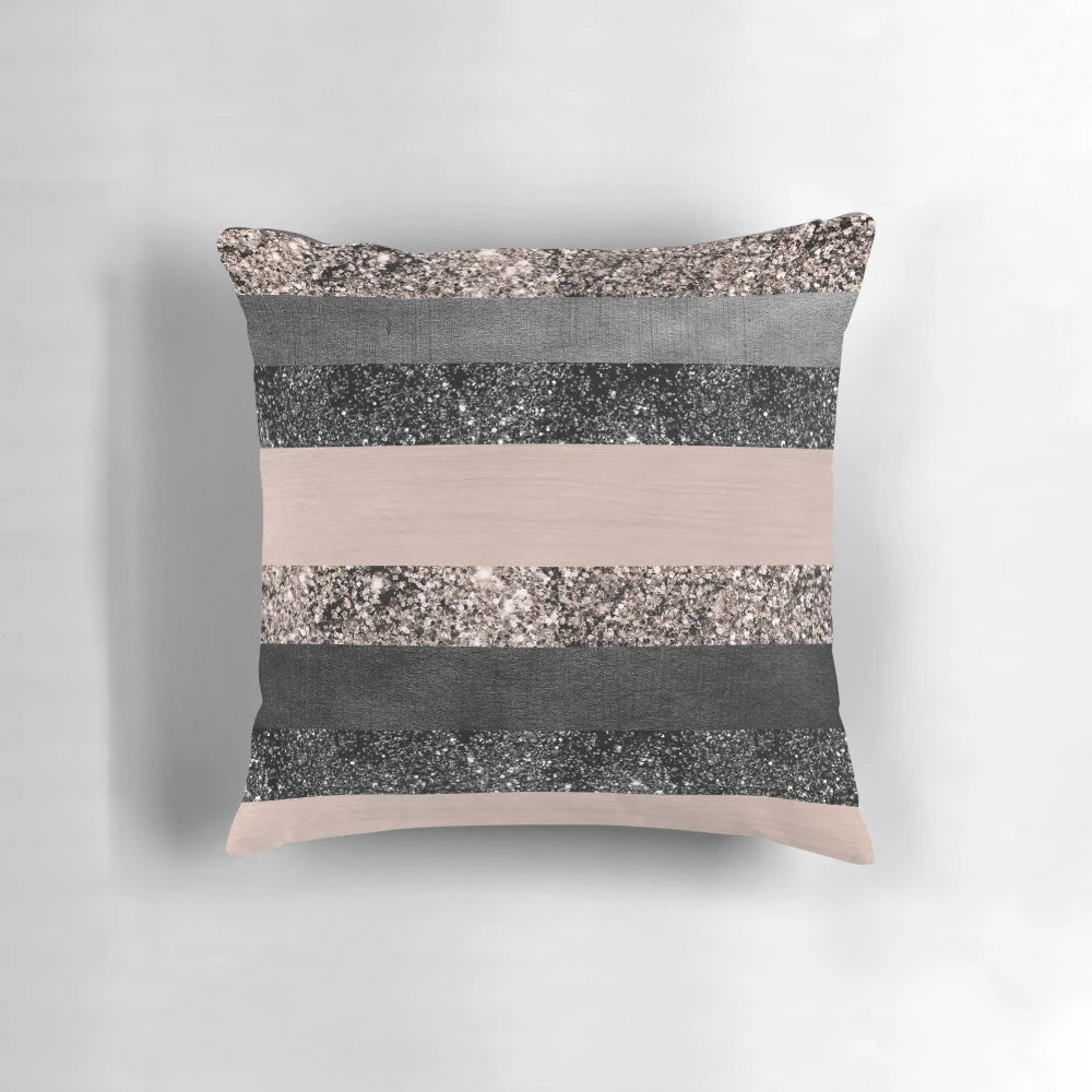 Closeup of a blush pink and grey striped decorative pillow with a glittery, luxurious texture.