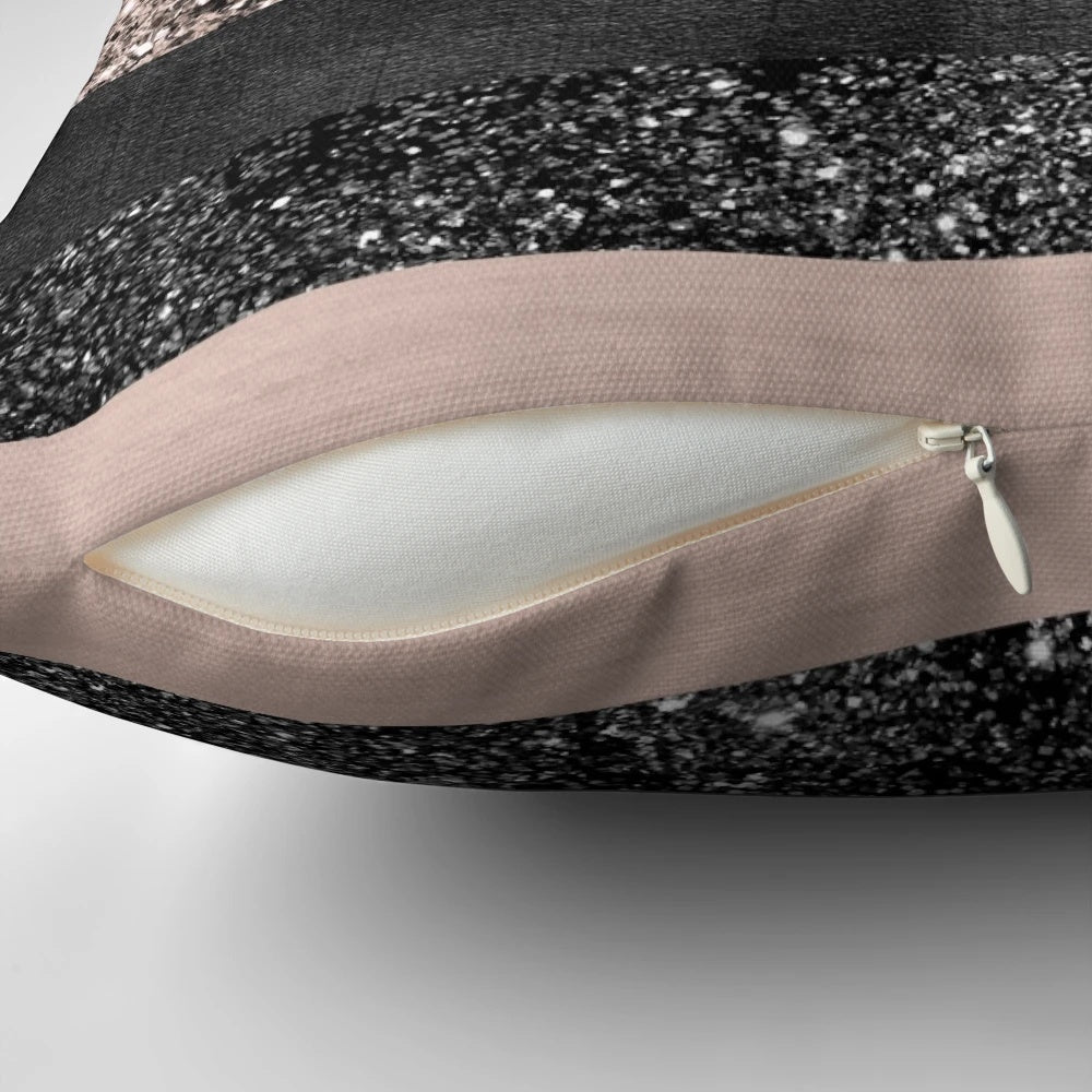 Closeup of a blush pink and grey striped decorative pillow with a glittery, luxurious texture.