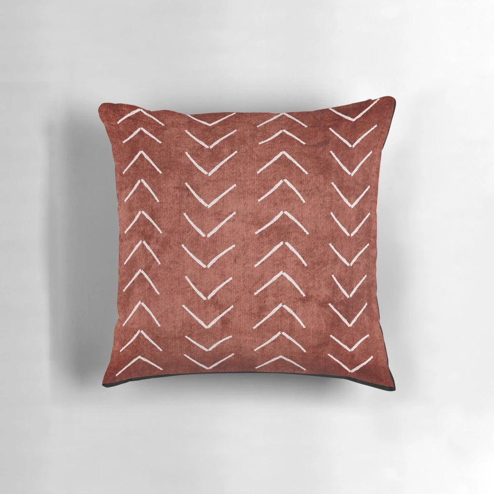 Decorative boho throw pillow with African mud cloth pattern in white and rust terracotta colors