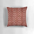 Decorative boho throw pillow with African mud cloth pattern in white and rust terracotta colors