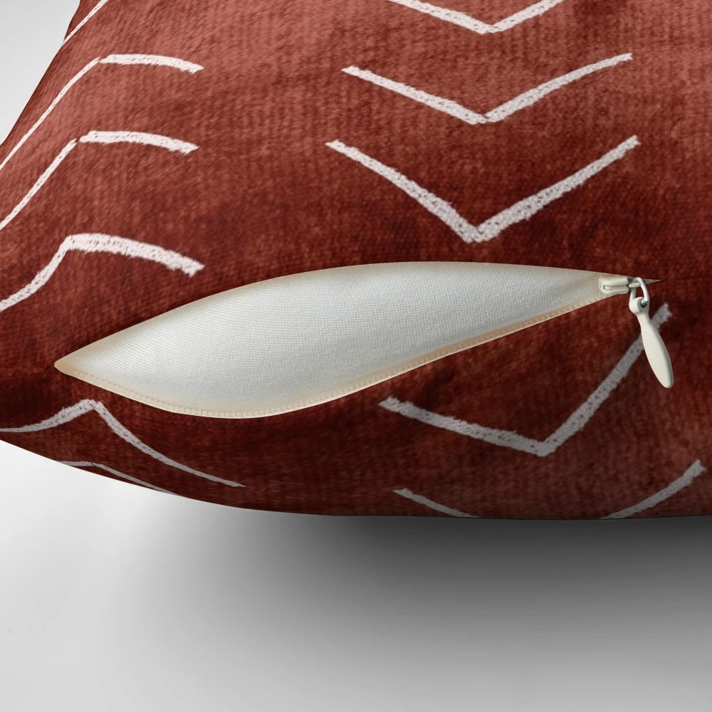 Decorative boho throw pillow with African mud cloth pattern in white and rust terracotta colors