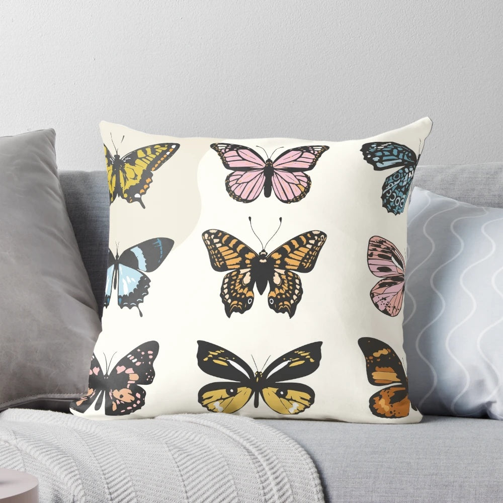 A soft, plush pillow featuring a colorful butterfly sticker pattern in pastel shades of pink, yellow, and mustard.