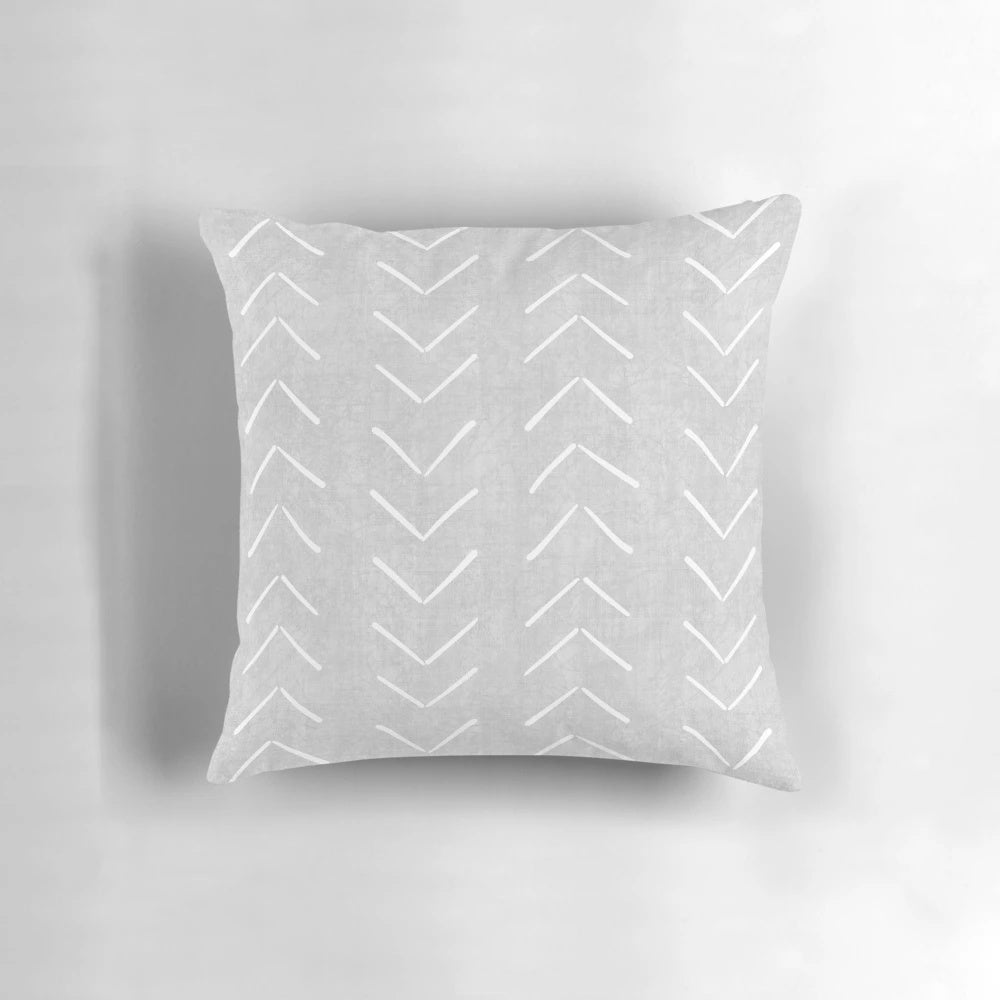 Boho-style grey and white throw pillow with geometric arrow design