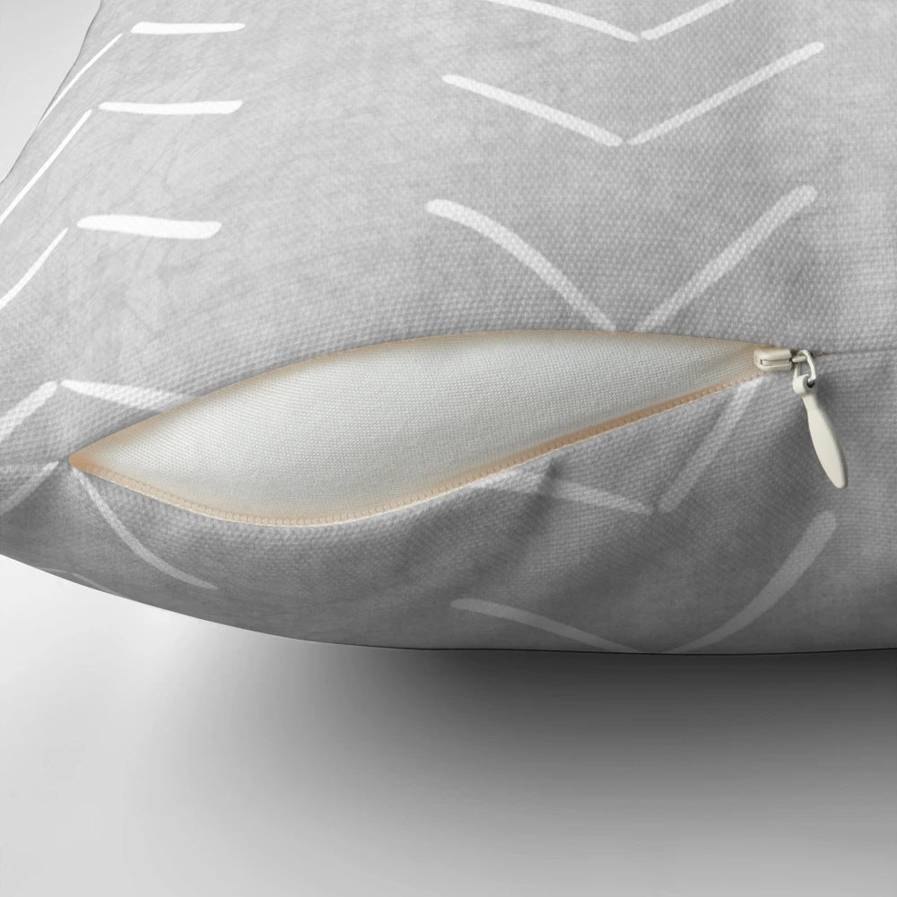 Boho-style grey and white throw pillow with geometric arrow design