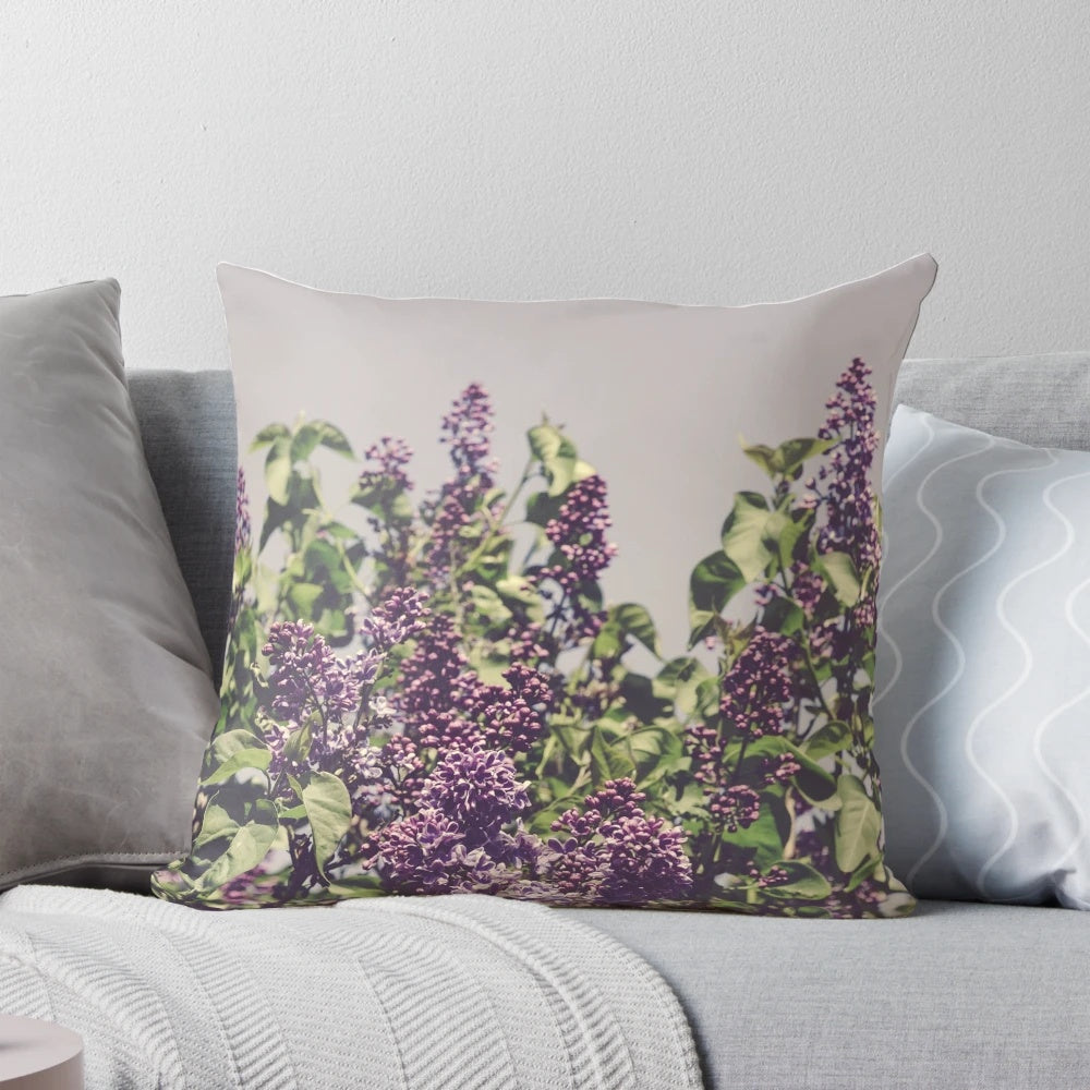 A Boho-style decorative pillow featuring vibrant purple lilacs and a minimalist design