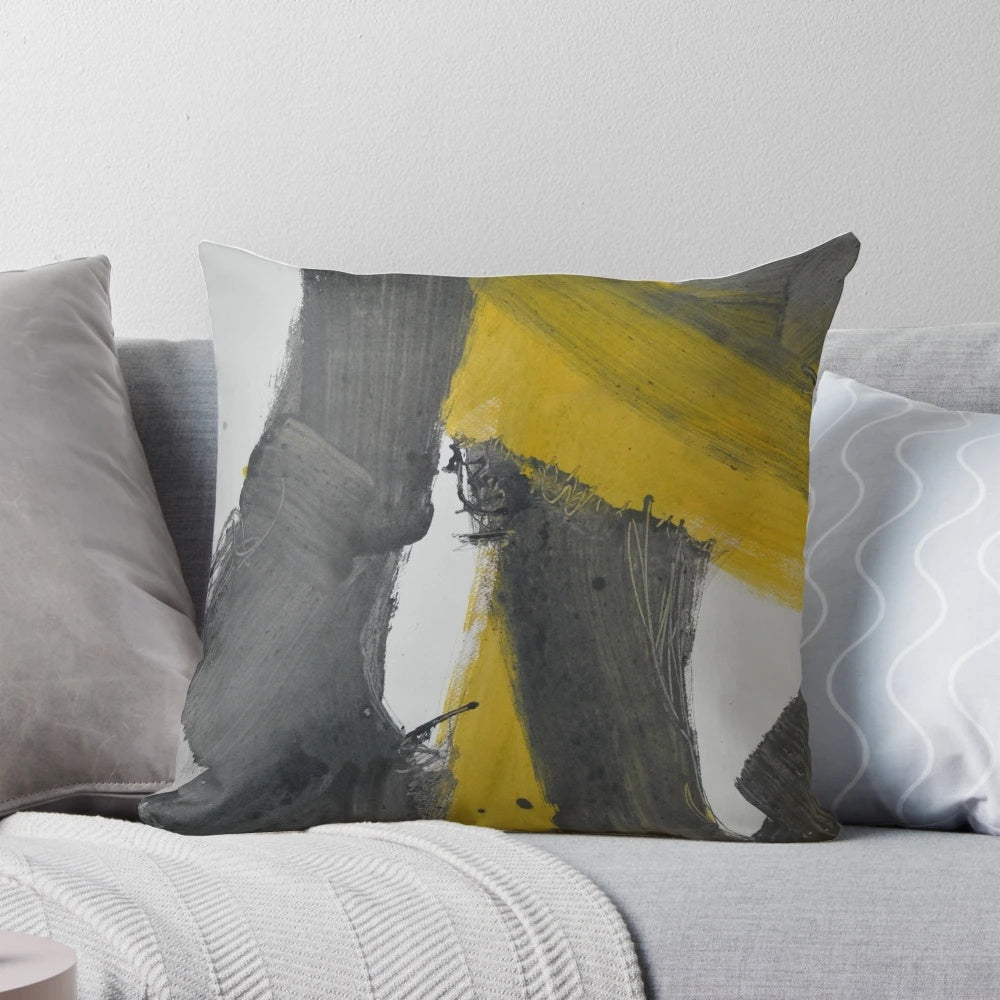 A Pillow featuring a bold, abstract art design in black, yellow, and gray with paint splash and streaks.