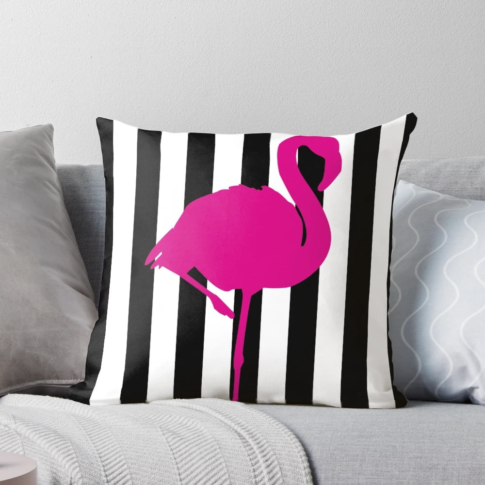 Vibrant hot pink flamingo on a black and white striped pillow, a bold and eye-catching graphic design.