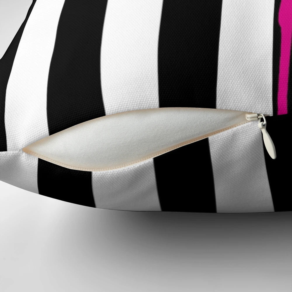 Vibrant hot pink flamingo on a black and white striped pillow, a bold and eye-catching graphic design.