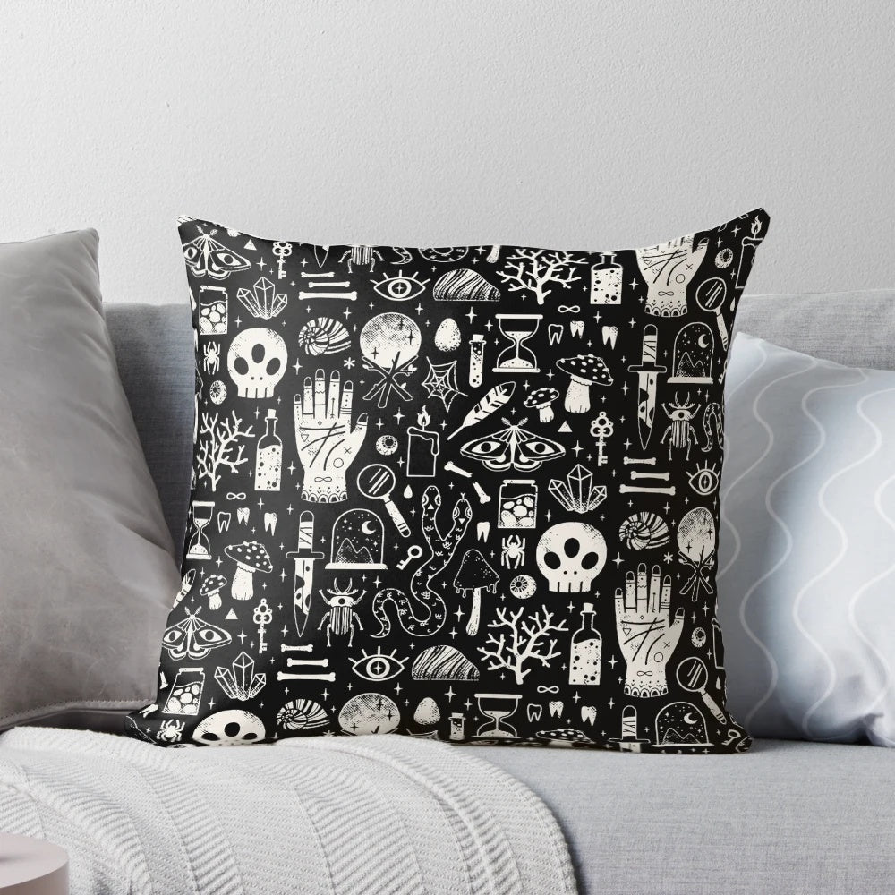 A black and white image of a bone black pillow, featuring a collection of natural elements like skulls, insects, and mushrooms.