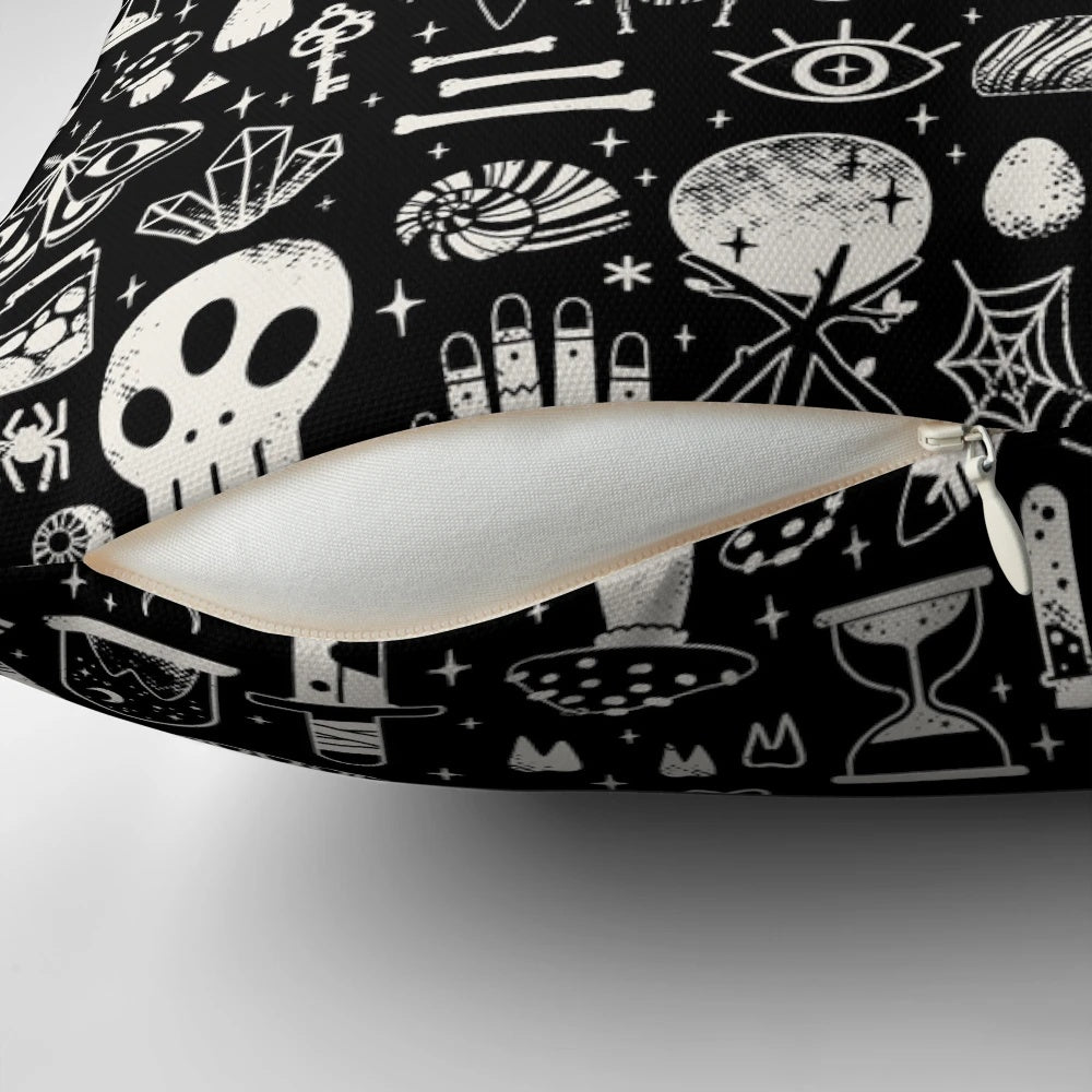 A black and white image of a bone black pillow, featuring a collection of natural elements like skulls, insects, and mushrooms.