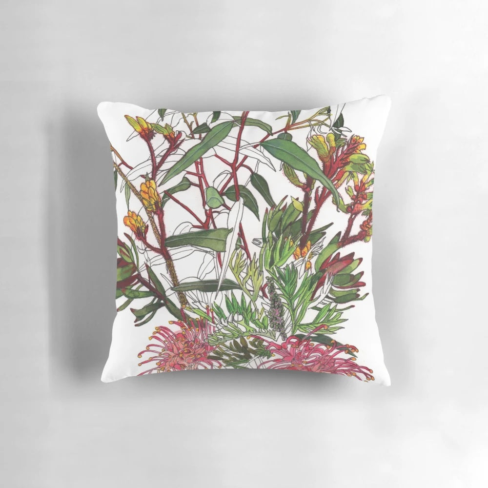 Colorful arrangement of Australian native flowers including kangaroo paw, protea, and eucalyptus leaves on a pillow.