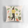 A cozy plant-themed pillow featuring a ginger cat lounging amidst a lush floral arrangement.
