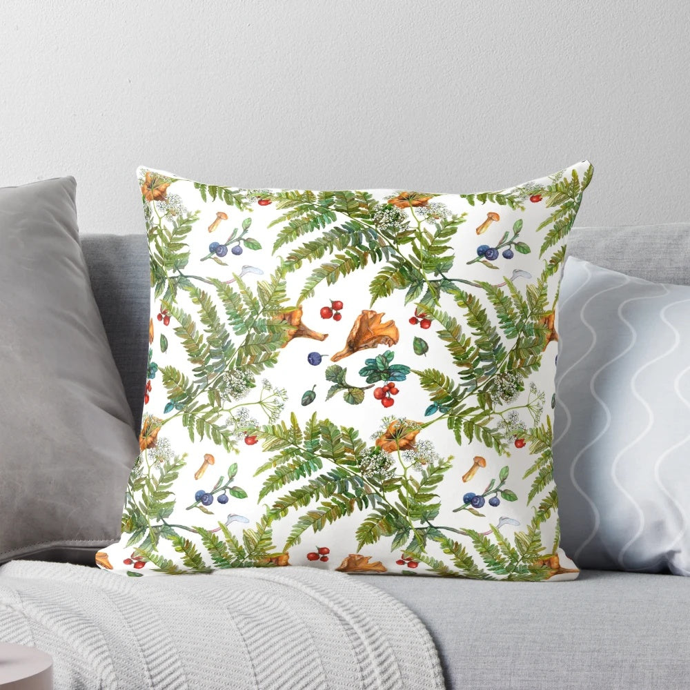 A watercolor painting of forest ferns, berries, and mushrooms on a decorative pillow.