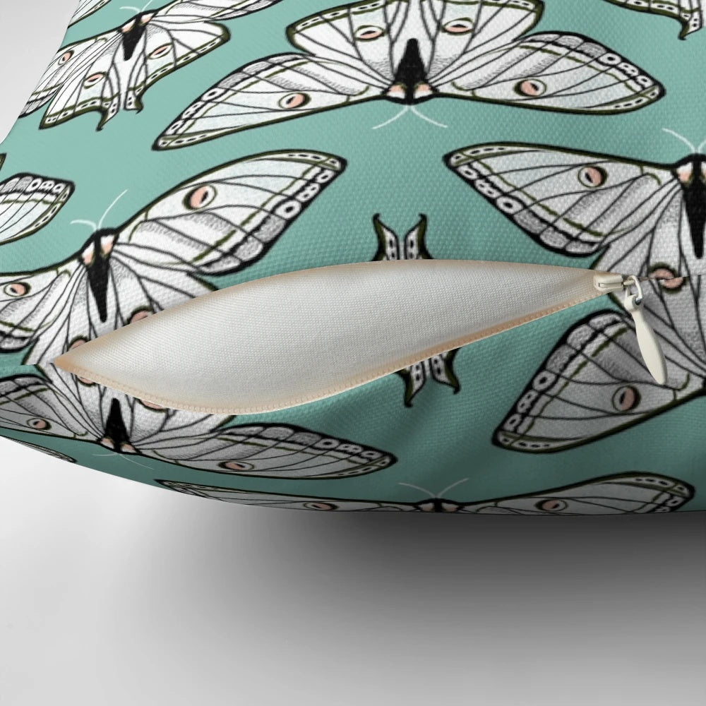 Botanical illustration of a luna moth on a white and green pillow