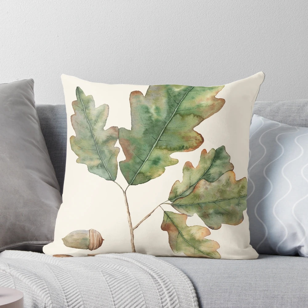 Decorative pillow featuring a watercolor illustration of oak leaves and acorns in autumn colors