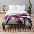 Soft and cozy plush blanket featuring a beautiful orchid design on a branch