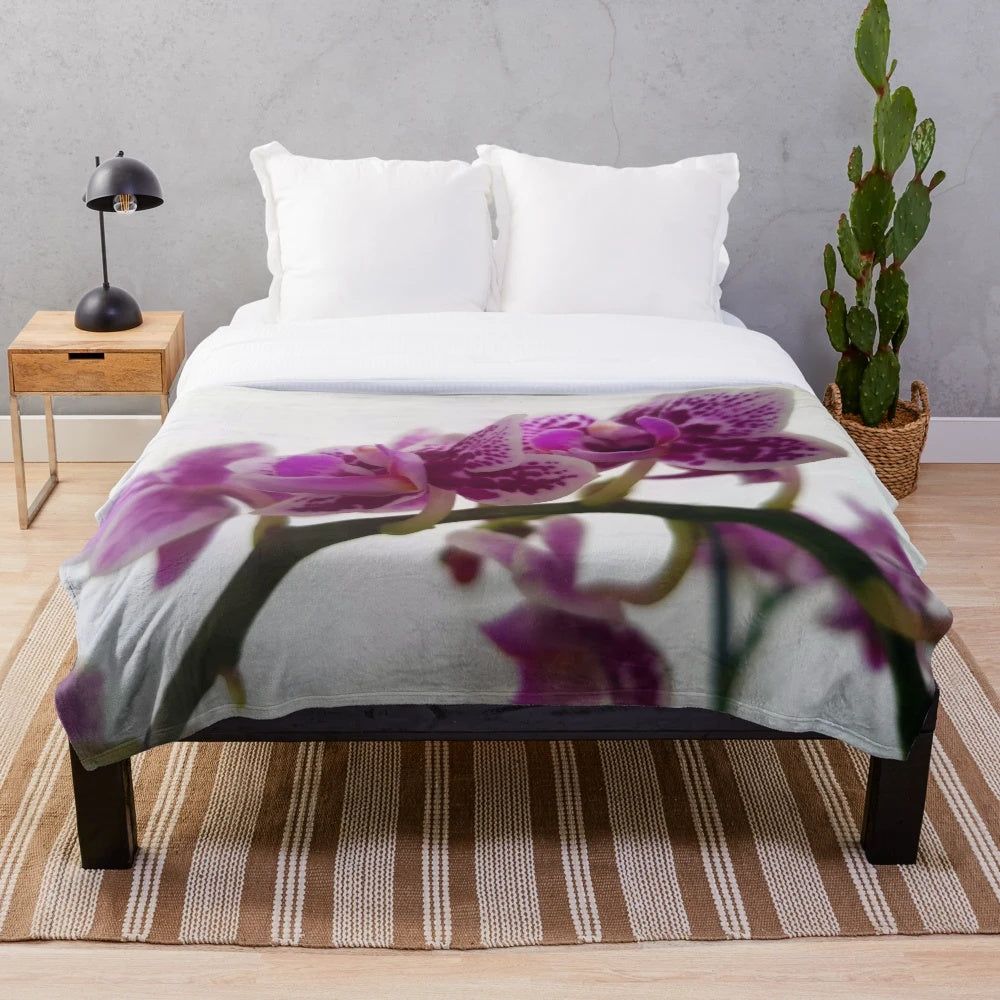Soft and cozy plush blanket featuring a beautiful orchid design on a branch