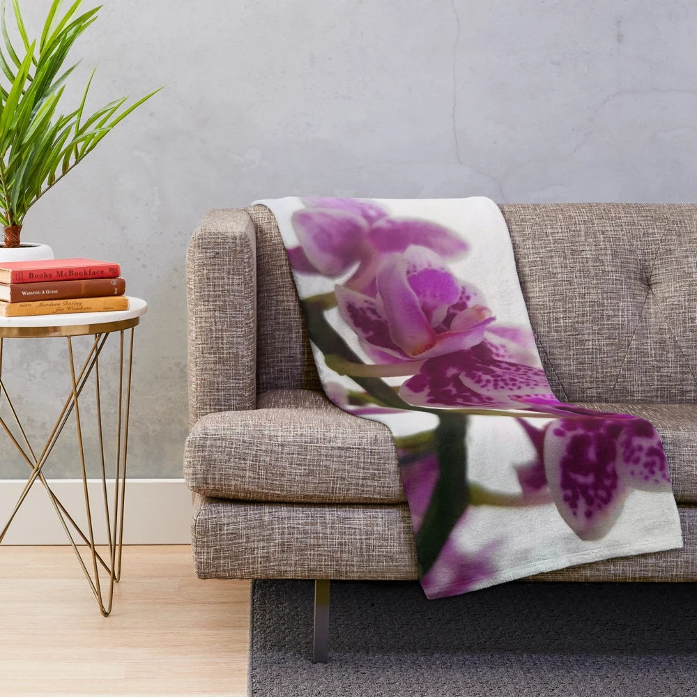 Soft and cozy plush blanket featuring a beautiful orchid design on a branch