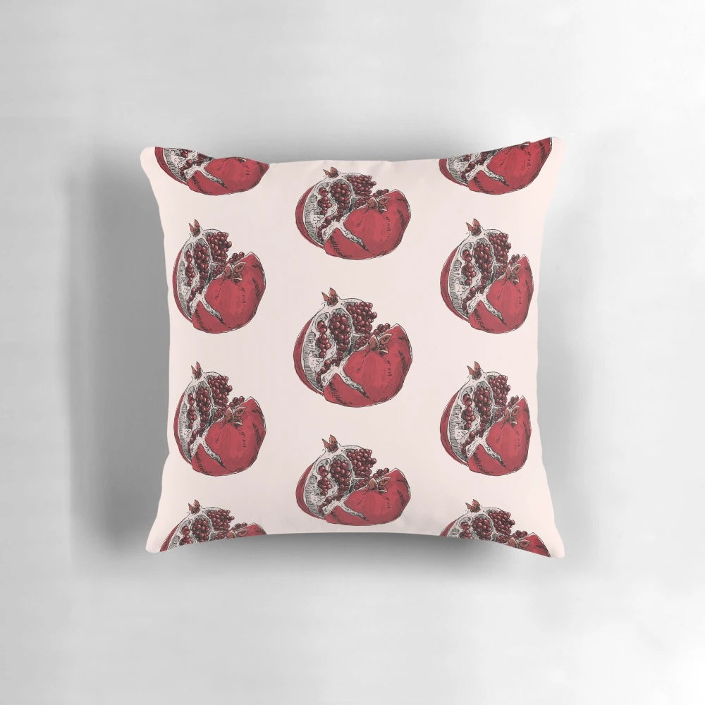 Detailed pen and ink sketch of a ripe, split open pomegranate on a decorative throw pillow.