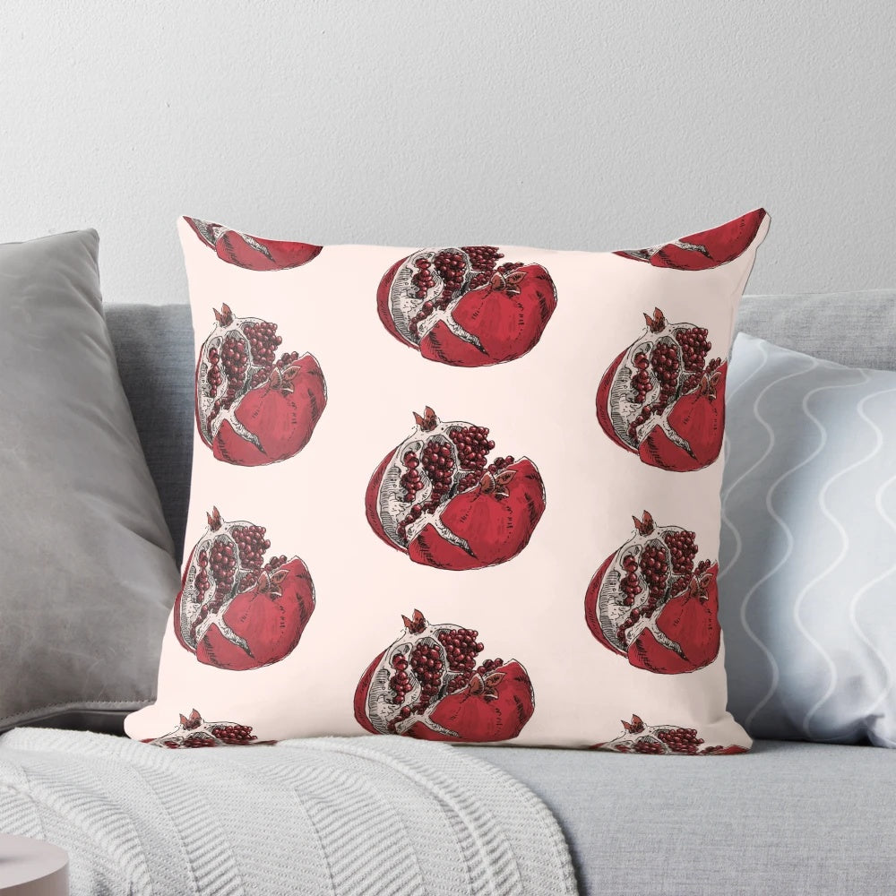 Detailed pen and ink sketch of a ripe, split open pomegranate on a decorative throw pillow.