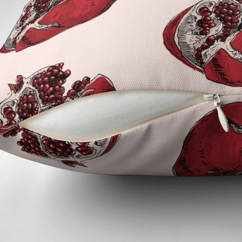 Detailed pen and ink sketch of a ripe, split open pomegranate on a decorative throw pillow.