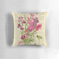 Closeup of a botanical print pillow featuring pink garden flowers on an aged, vintage-style book page.