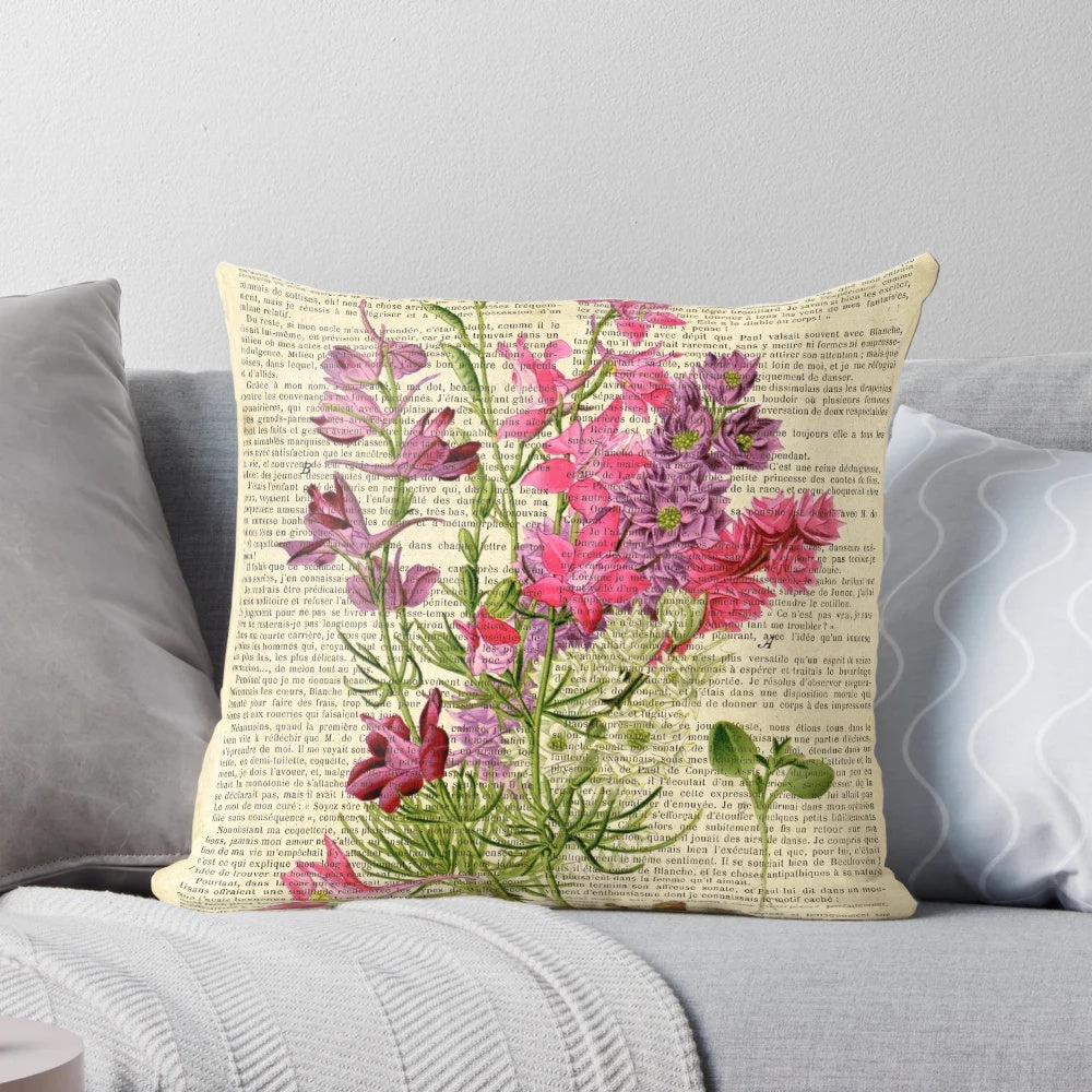 Closeup of a botanical print pillow featuring pink garden flowers on an aged, vintage-style book page.