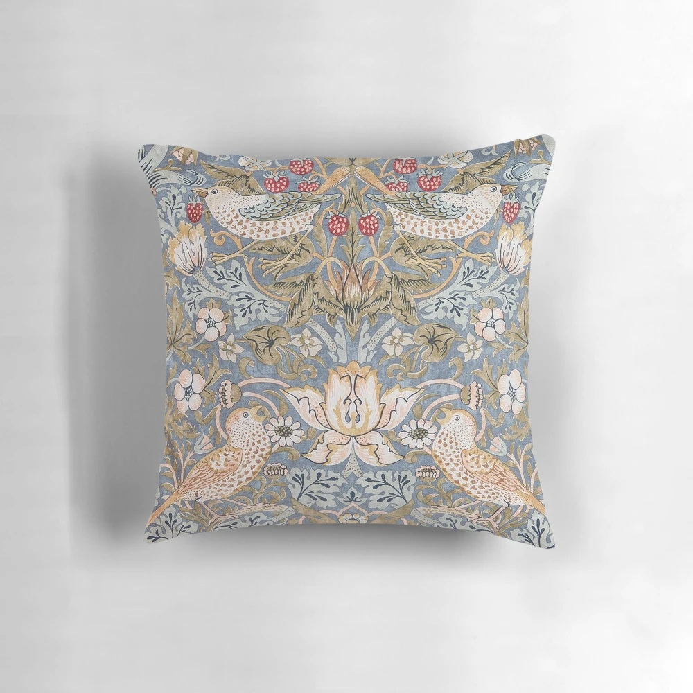 A close-up view of a decorative pillow featuring the iconic "Strawberry Thief" pattern designed by William Morris.